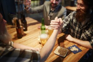 men arm wrestling at a bar
