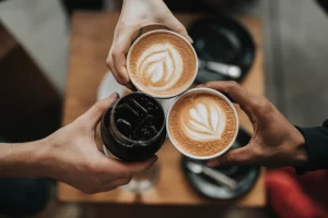 Three people cheering iced coffee